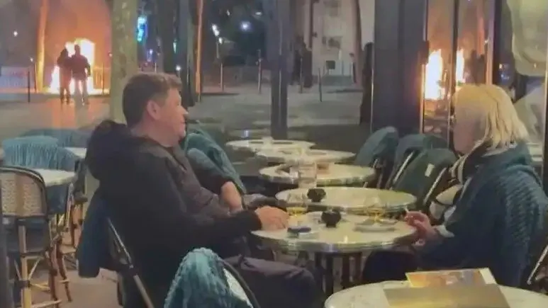 情侣无视火焰在抗议现场淡定饮酒交谈